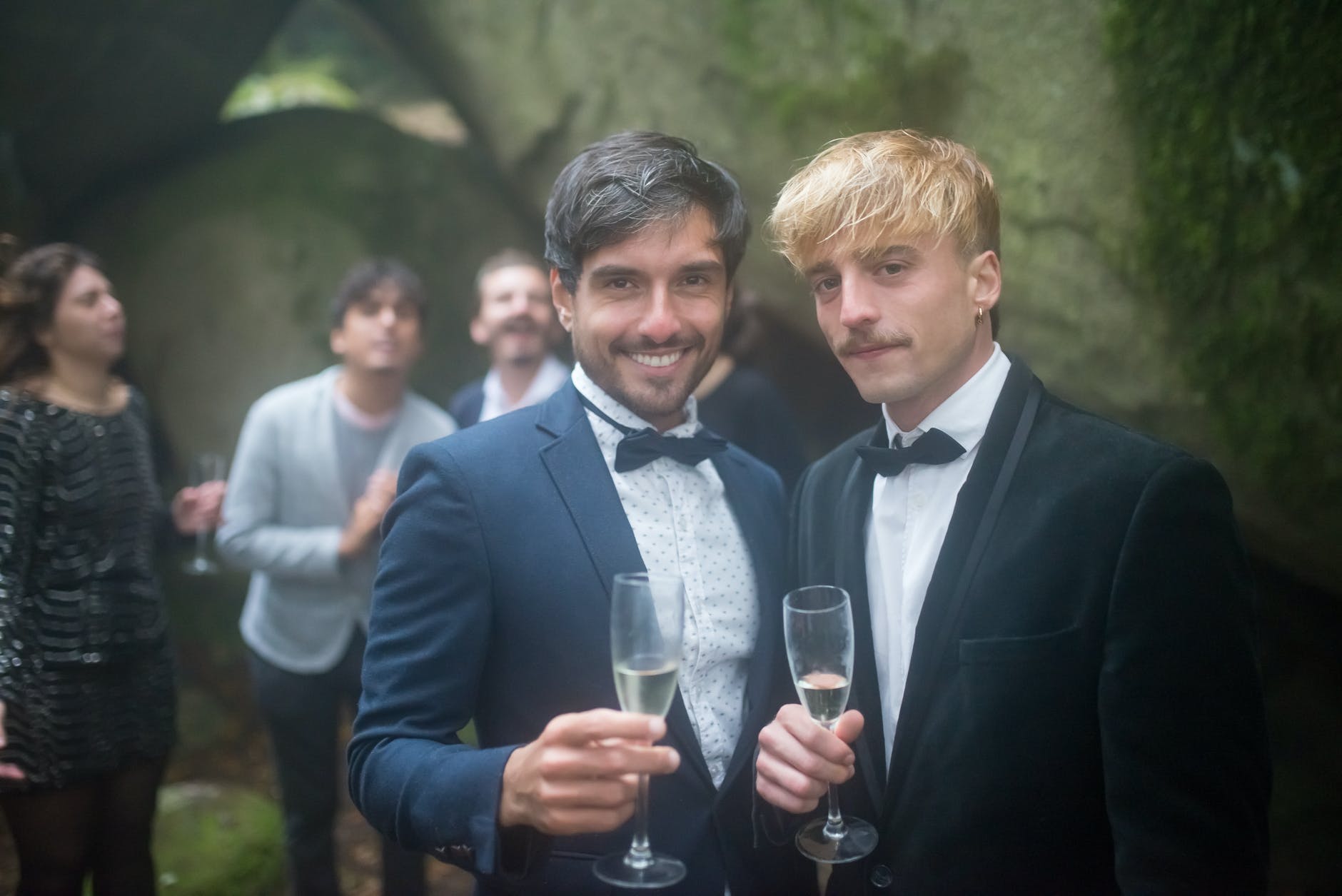 men in black suits holding champagne flutes